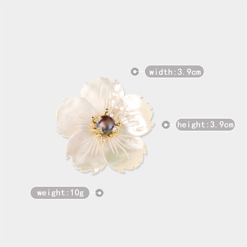 A single flower-shaped decorative accessory or brooch with pale iridescent petals and a dark center, shown on a light gray background with overlaid dimension labels reading width 3.9 cm, height 3.9 cm.