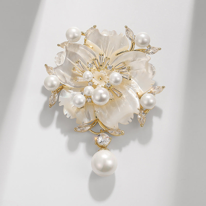 Decorative brooch with pearls and crystals on a light gray background