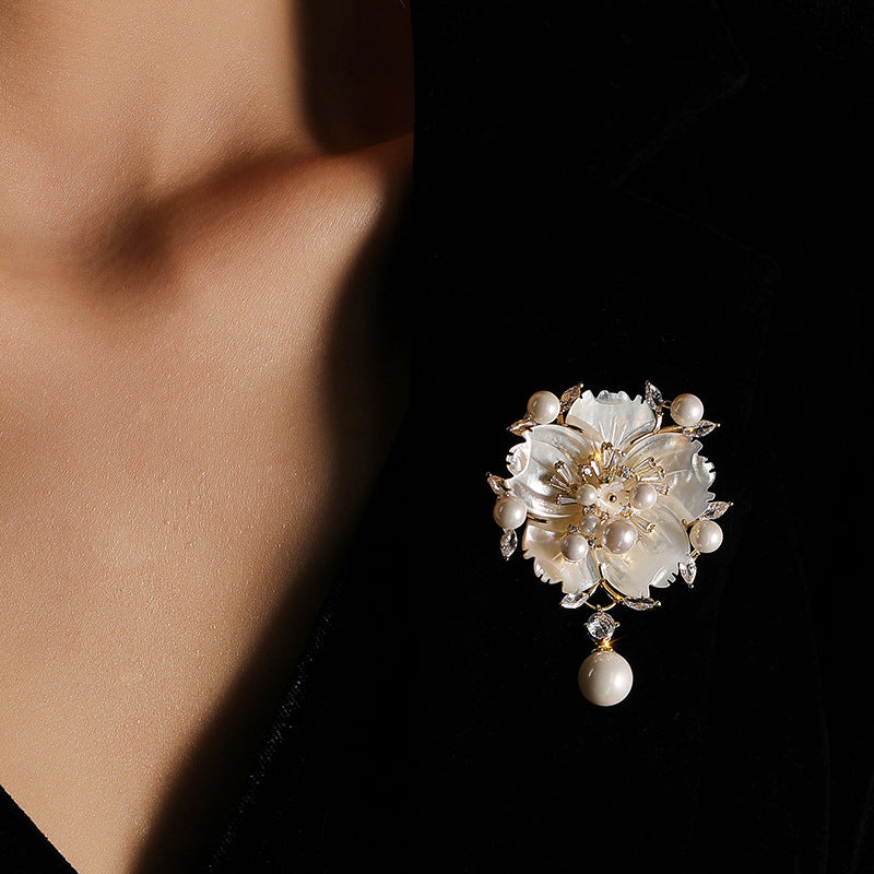 Close-up of a floral brooch with pearls on a dark background